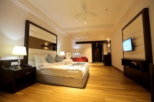 a hotel room with a bed and a television at Hotel Stella Continental in Phagwāra