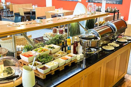a buffet of food on a counter in a restaurant at Familienhotel Citylight in Berlin