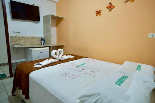 a room with a bed with two towels on it at Pousada Familly Porto de Galinhas in Porto De Galinhas