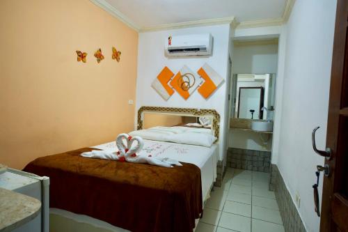 a hotel room with a bed with towels on it at Pousada Familly Porto de Galinhas in Porto De Galinhas