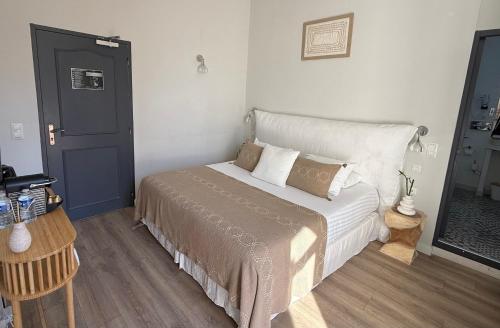 a bedroom with a bed and a table with a chair at Villa Claudia Hotel Cannes Centre - Parking in Cannes