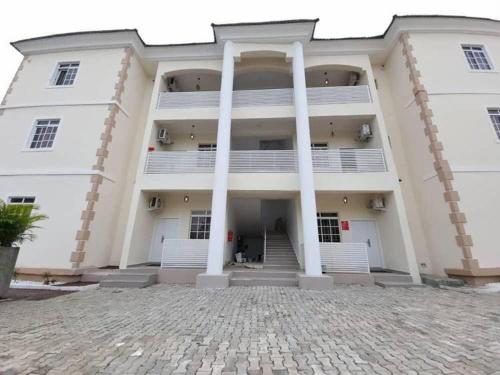 a large white building with columns in front of it at Hometime Utako in Abuja