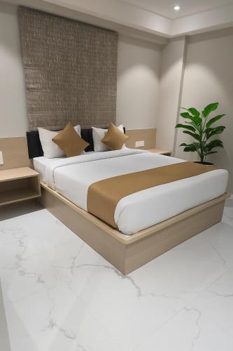 a bedroom with a large bed and a plant at Hotel Coome Inn in Chākan