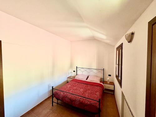 a bedroom with a red bed in a white room at Rovellasca Tra Como e Milano in Rovellasca