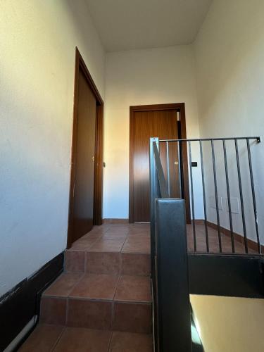 a hallway with a staircase with a door and a stair railing at Rovellasca Tra Como e Milano in Rovellasca
