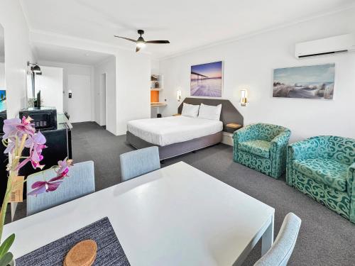 a hotel room with a bed and a table at Golden Sands Motor Inn in Forster