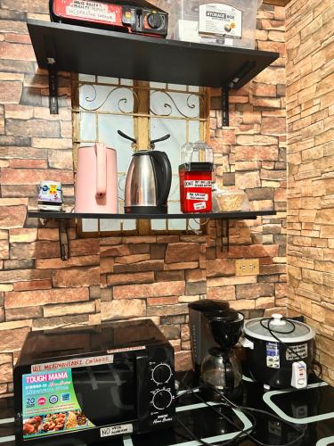 a kitchen with a counter top with a microwave at 7pax, 2 AC BR,Videoke,Games,Netflix,Cook,Parking in Rodriguez