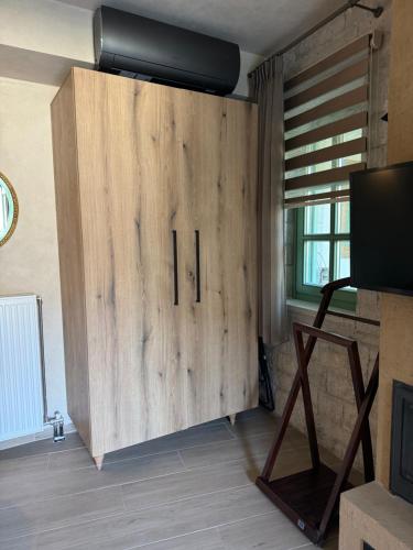 a large wooden cabinet in a room with a television at Aristi boutique stonehouse with attic in Aristi