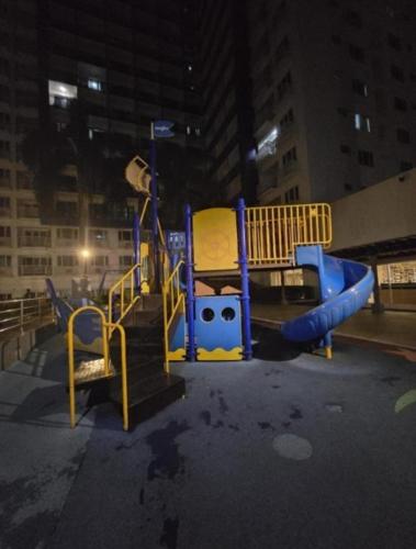 a playground with a slide in a city at night at CHIC ROOM pasay sea residence in Manila