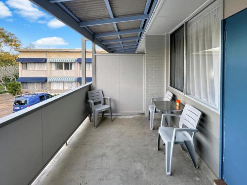 a patio with a table and chairs on a balcony at Golden Sands Motor Inn in Forster