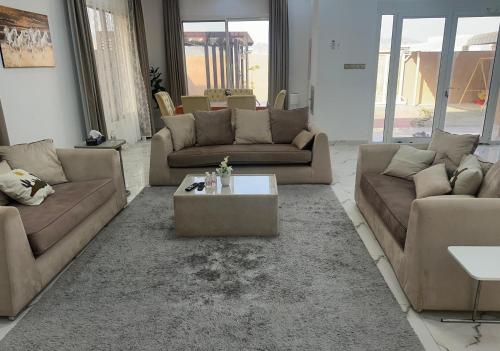 a living room with couches and a coffee table at Jabal Masfut Villa استراحة جبل مصفوت in Sharīyah