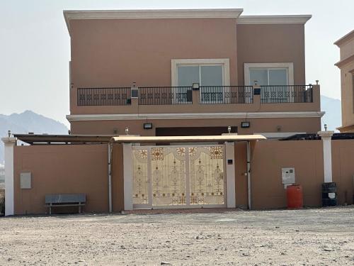 a building with a large door with a balcony at Jabal Masfut Villa استراحة جبل مصفوت in Sharīyah