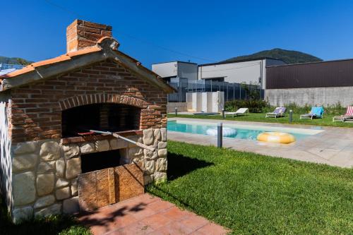 a brick pizza oven next to a swimming pool at Santa Maria Apartments in Forino