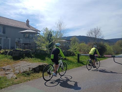 zwei Personen fahren mit dem Fahrrad eine Straße entlang, an der ein Baustellenschild hängt in der Unterkunft Notre Renardière, Gîtes à Saulxures-sur-Moselotte, Hautes-Vosges in Saulxures-sur-Moselotte