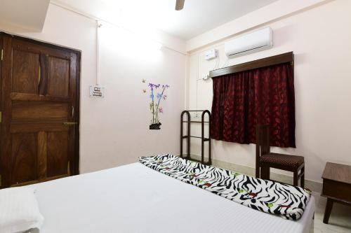 a bedroom with a bed and a door and a chair at Blue Bridge Homes in Port Blair