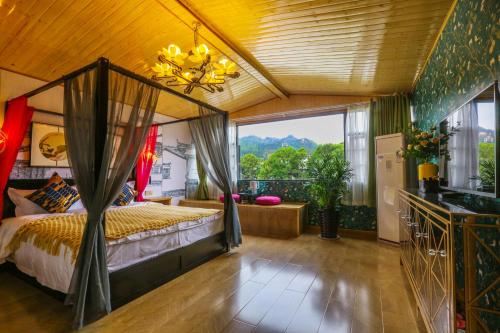 a bedroom with a bed and a large window at XI SHANG YUN JIAN Inn in Hanqiyu