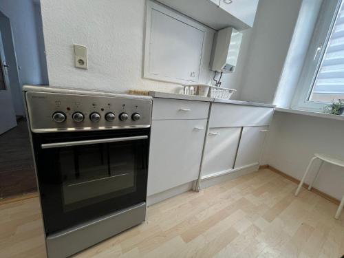 a kitchen with a stainless steel stove and white cabinets at Beautiful apartment for 5-7 guests in Zeitz