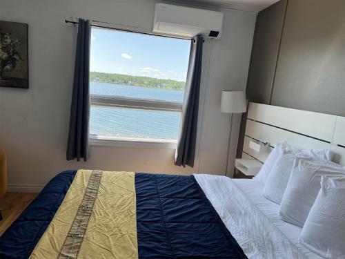 シドニーにあるHarbourview Inn, SureStay Collection by Best Westernのベッドと大きな窓のある寝室