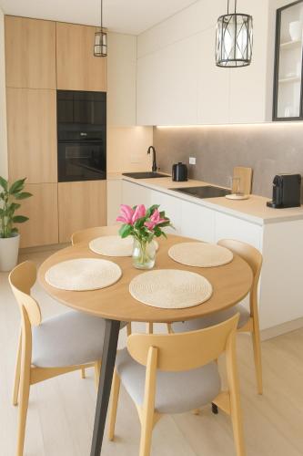 a kitchen with a wooden table and chairs with pink flowers at Apartament Zielone Wzgórze 3 in Jelenia Góra