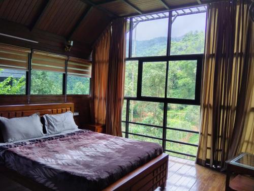 a bedroom with a bed in a room with windows at Moonrise Valley Freshwave Resorts Pvt Ltd in Koroth