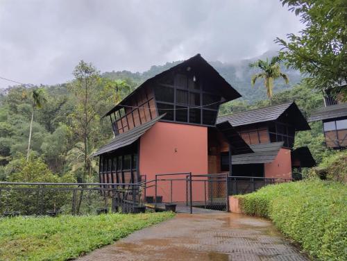 a house with a black roof and pink at Moonrise Valley Freshwave Resorts Pvt Ltd in Koroth