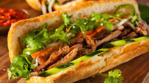 a sandwich with meat and vegetables on a table at Khách sạn Thu Nga in Mai Chầu