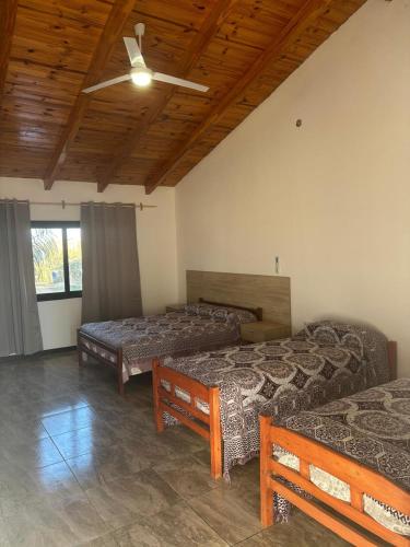 a room with three beds and a ceiling fan at Rdsa Paso in Paso de la Patria