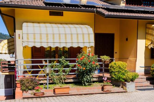 a yellow house with potted plants on the steps at Santa Maria Apartments in Forino