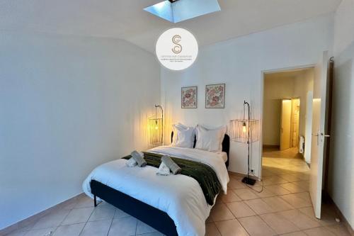 a bedroom with a large bed with white sheets at Numéro Quarante Arles Center in Arles