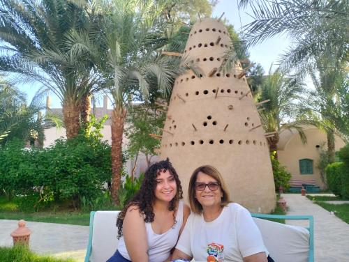 two women sitting in front of a sand castle at Sekhmet Retreat Centre in Luxor