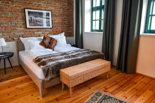 a bedroom with a bed and a brick wall at Ugron Castle Fiatfalva in Cristuru Secuiesc
