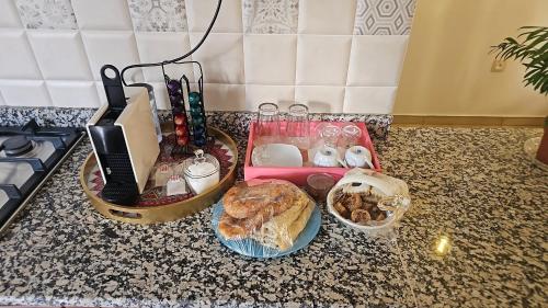 Una encimera con una bandeja de comida y una cesta de pan. en HCH Momo, en Tizi Ouzou