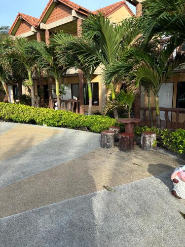 a house with palm trees in front of it at Friendly by The Sea in Haad Rin