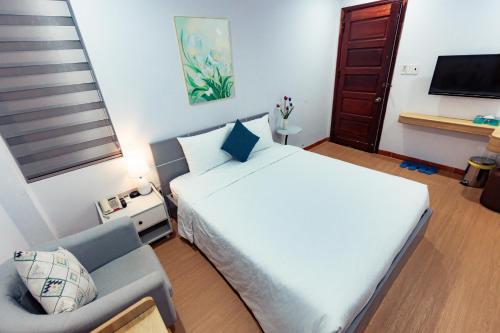 a bedroom with a large white bed and a couch at Sunshine Hotel in Buon Ma Thuot