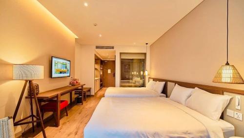 a hotel room with two beds and a desk at Mandala Cham Bay Mui Ne in Ấp Nhơn Hòa