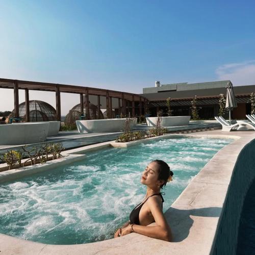 a woman sitting in a swimming pool at Mandala Cham Bay Mui Ne in Ấp Nhơn Hòa