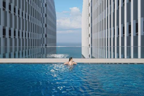 a woman sitting in a swimming pool in a building at Mandala Cham Bay Mui Ne in Ấp Nhơn Hòa