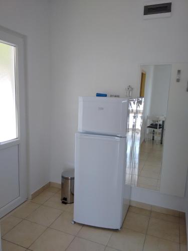 a white refrigerator in a room with a window at Apartments Vukas in Lumbarda