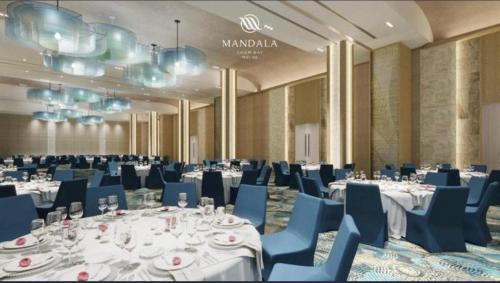 a banquet hall with white tables and blue chairs at Mandala Cham Bay Mui Ne in Ấp Nhơn Hòa