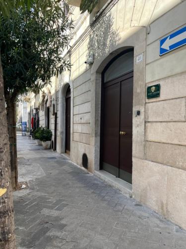 een gebouw met twee garagedeuren naast een straat bij Loft Green Trani in Trani