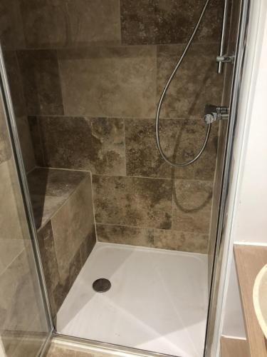 a shower in a bathroom with a glass door at Charmant et Lumineux in Caussade