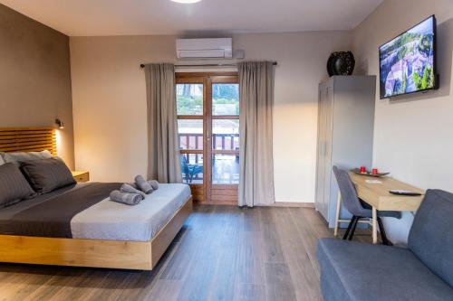 a bedroom with a bed and a desk and a couch at Meteora Living Rooms in Kastrákion