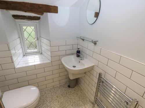 a white bathroom with a sink and a toilet at 11 Hollin Well Cottage in Sowerby Bridge