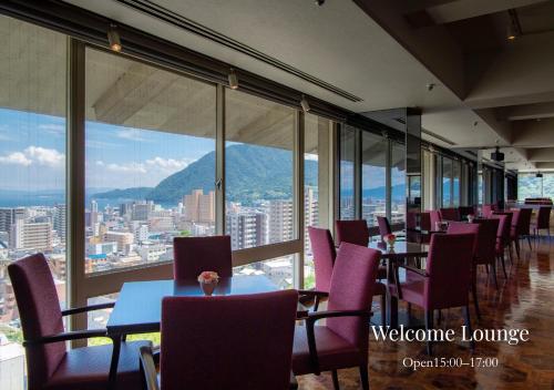 a restaurant with purple chairs and tables and windows at Shiragiku in Beppu