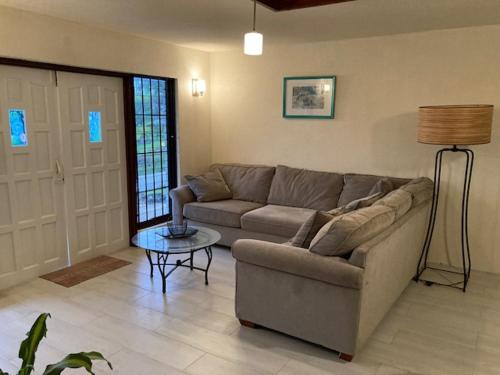 a living room with a couch and a table at Yellow Doors - Tranquil comfortable retreat in Saint James
