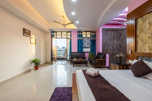 ノイダにあるHotel Warm Welcome - Noida Sector 20のベッドとリビングルームのある寝室