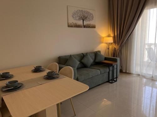 a living room with a couch and two tables at Elegant One-bedroom apartment in Al Hamrah village in Ras al Khaimah