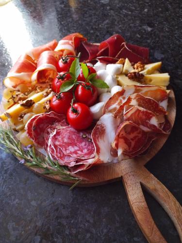 a plate of food with meat and tomatoes on a table at Les Chambres du 11 - Chambres et Table d'hôtes in Chevigny