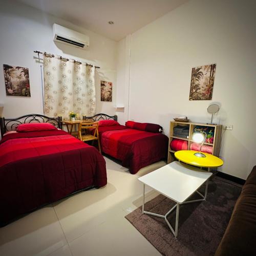 a living room with two beds and a tv at Tiger Cave Home in Krabi