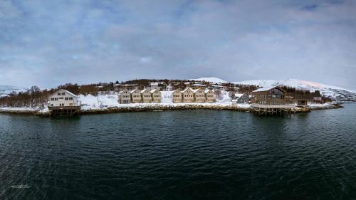 a group of houses on an island in the water at Steam Pier Adventure Hotel in Kvaløya